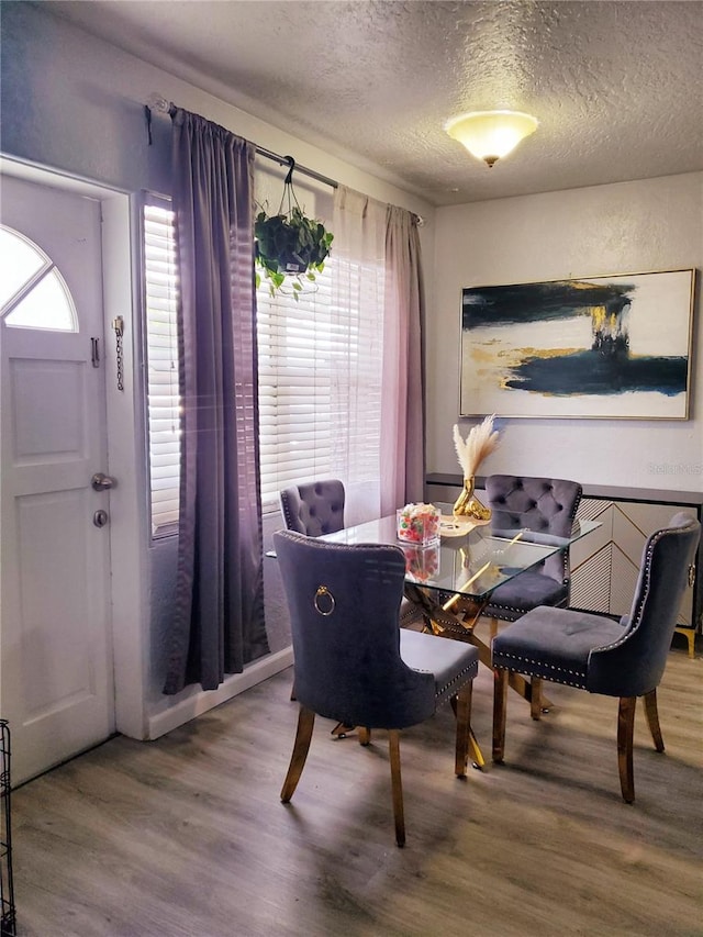 dining area featuring hardwood / wood-style flooring and a textured ceiling