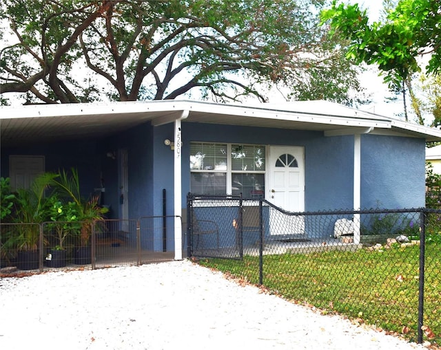 doorway to property with a lawn, a porch, and a carport