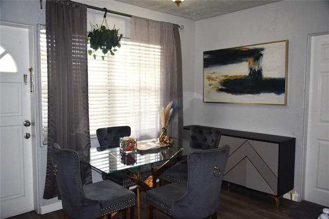 dining space featuring dark hardwood / wood-style flooring and a textured ceiling