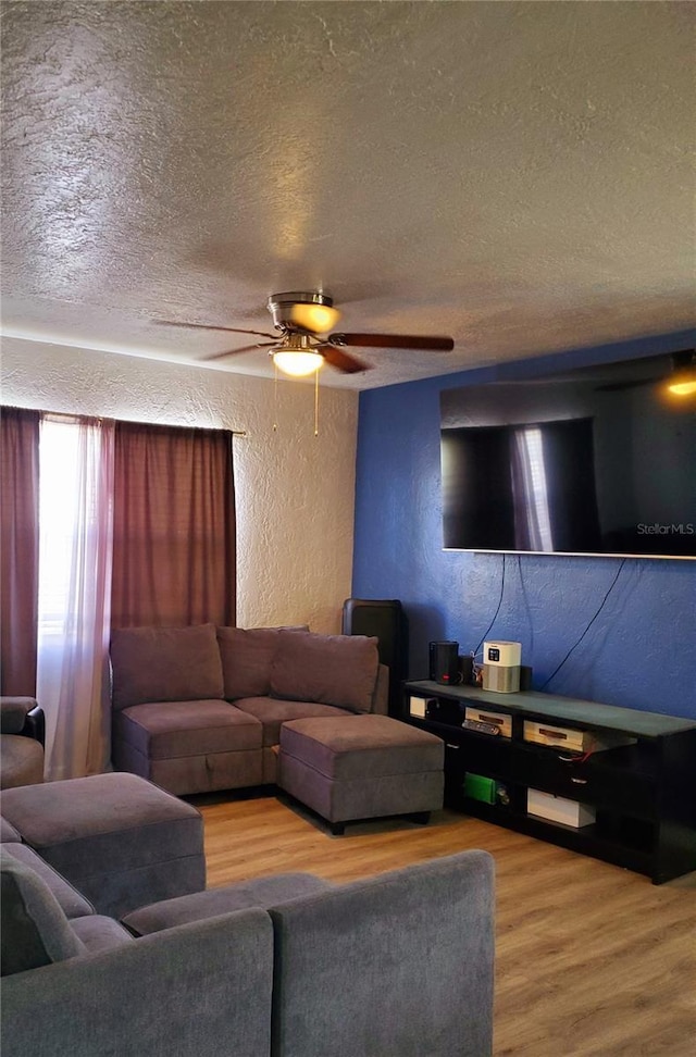 living room featuring hardwood / wood-style floors, a textured ceiling, and ceiling fan