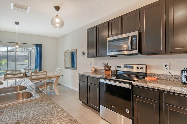 kitchen featuring appliances with stainless steel finishes, dark brown cabinets, and hanging light fixtures