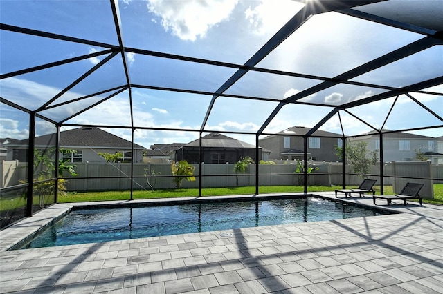 view of pool featuring glass enclosure, a patio area, and a lawn