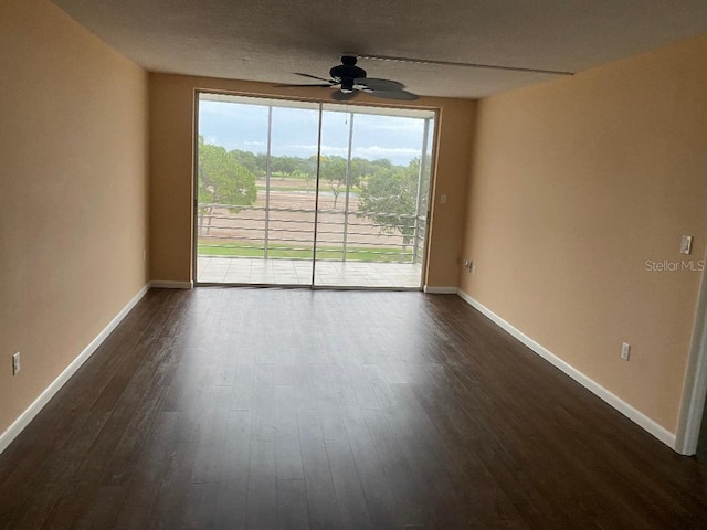 empty room featuring dark wood-type flooring and ceiling fan