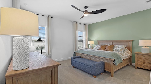 bedroom with light carpet, multiple windows, and ceiling fan