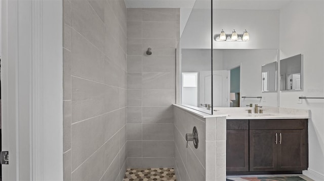 bathroom featuring a tile shower and vanity