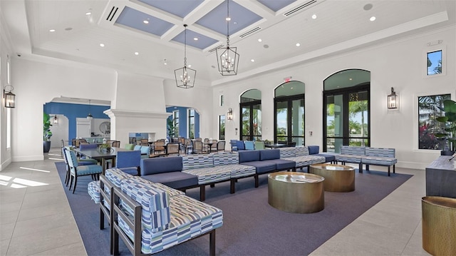 living room with light tile patterned floors, a towering ceiling, and coffered ceiling