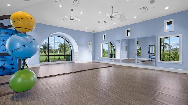 exercise room featuring a high ceiling and ceiling fan