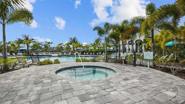 view of pool featuring a hot tub and a patio area