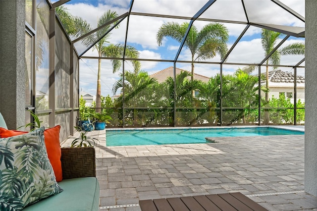 view of swimming pool featuring a patio area and glass enclosure