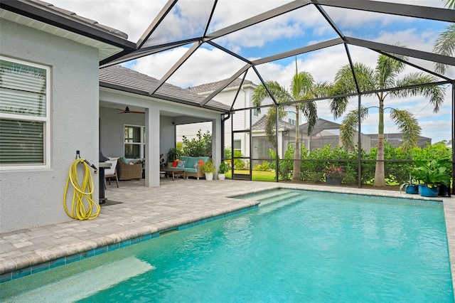 view of swimming pool featuring outdoor lounge area, ceiling fan, a lanai, and a patio