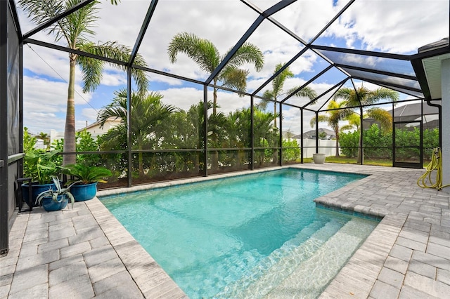 view of swimming pool with a patio area and a lanai