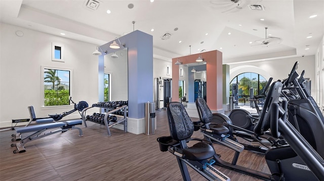 workout area with a raised ceiling, high vaulted ceiling, and ceiling fan