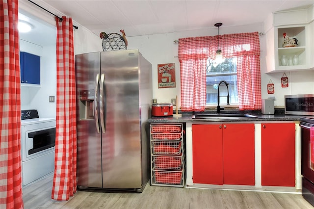 kitchen featuring washer / dryer, light wood-type flooring, stainless steel appliances, and sink