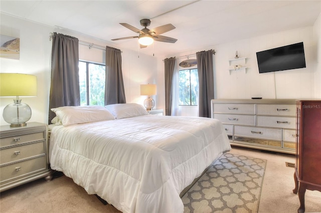 carpeted bedroom with multiple windows and ceiling fan