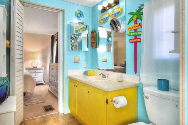 bathroom with tile patterned flooring, vanity, and toilet