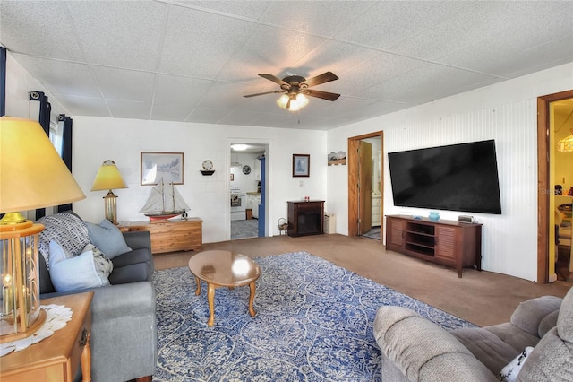 living room with ceiling fan and carpet