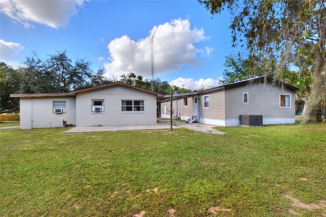 rear view of property with a yard, a patio, and central air condition unit