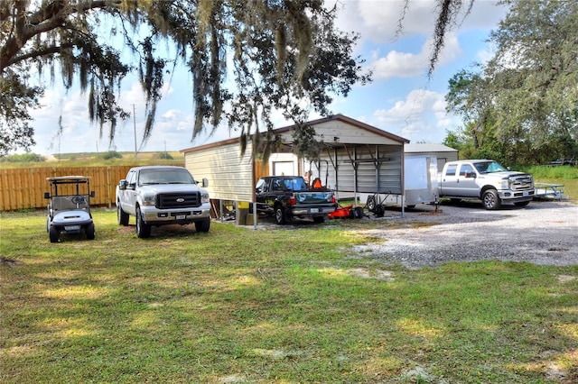 exterior space with a carport and a lawn