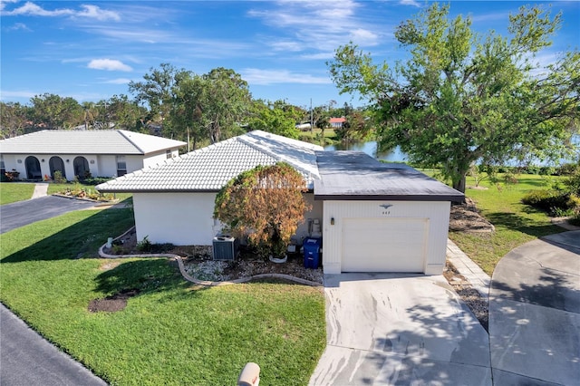 view of side of home with a lawn, a garage, and cooling unit