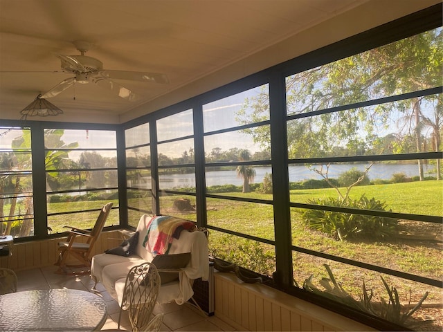 sunroom / solarium featuring a water view, ceiling fan, and plenty of natural light