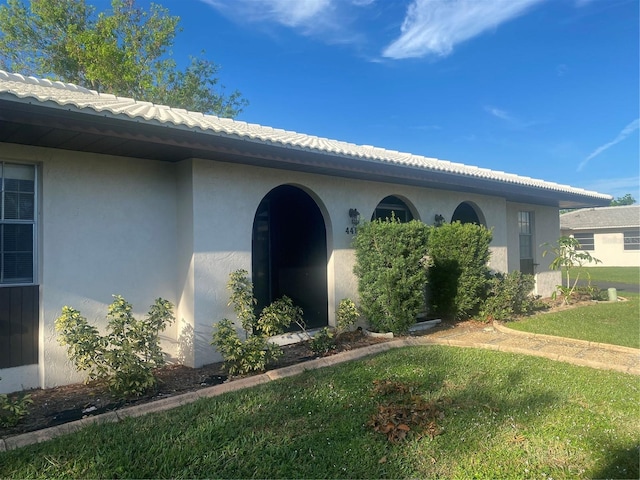 view of exterior entry with a yard