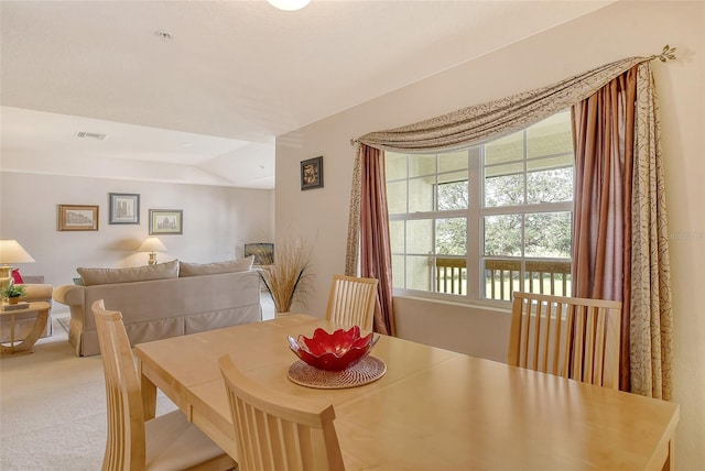 dining area featuring carpet floors and vaulted ceiling