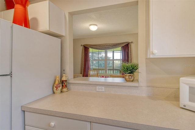 381 Bobby Jones Rd Unit 381, Sarasota, FL 34232 - kitchen with white appliances, light countertops, and white cabinets