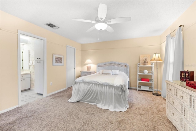 carpeted bedroom featuring ceiling fan and ensuite bathroom