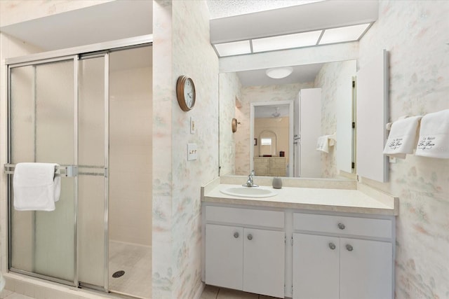 bathroom featuring tile patterned flooring, vanity, and a shower with shower door