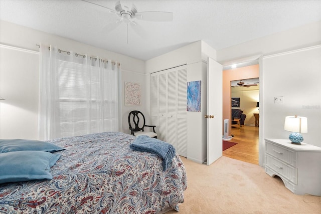 carpeted bedroom featuring ceiling fan and a closet