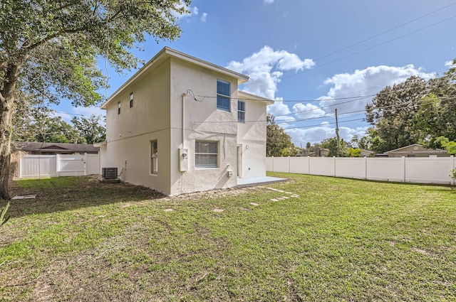 rear view of property with a lawn and central AC