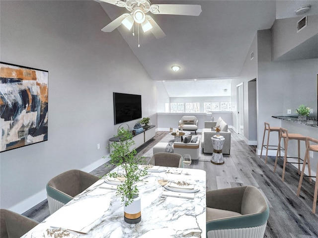 dining area with light hardwood / wood-style flooring, high vaulted ceiling, and ceiling fan