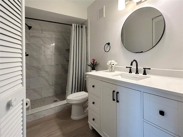 bathroom with a shower with shower curtain, vanity, hardwood / wood-style flooring, and toilet