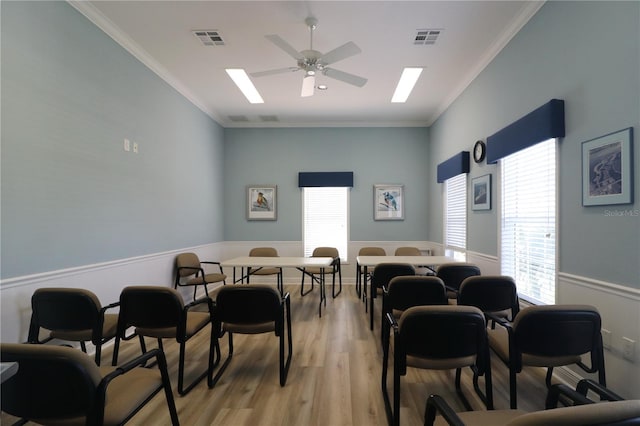 dining space with ceiling fan, crown molding, and light hardwood / wood-style floors