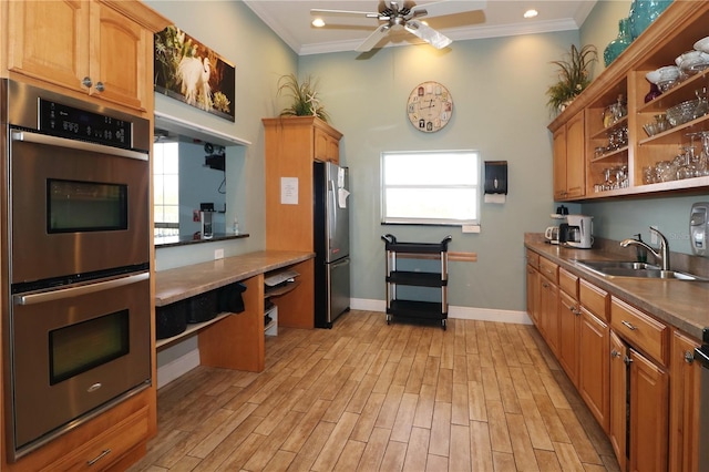 kitchen with light wood-type flooring, stainless steel appliances, a healthy amount of sunlight, crown molding, and sink