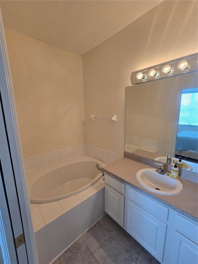 bathroom featuring tiled bath, tile patterned flooring, and vanity