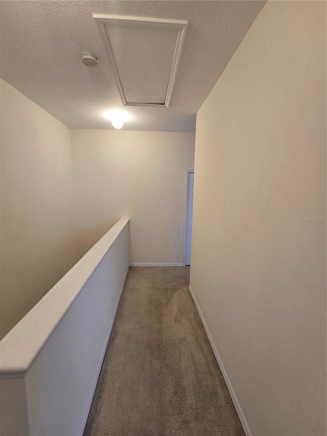 hall featuring a textured ceiling and carpet floors