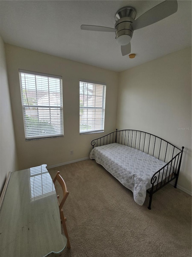 bedroom featuring ceiling fan, carpet flooring, and multiple windows