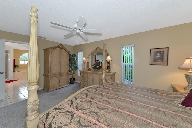 bedroom featuring light carpet, a textured ceiling, and ceiling fan