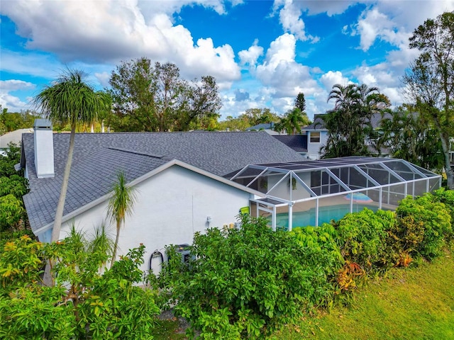 back of property with a lanai and a swimming pool