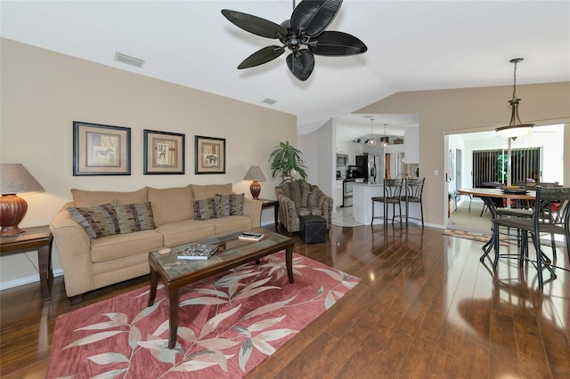 living room with lofted ceiling, ceiling fan, and dark wood-type flooring