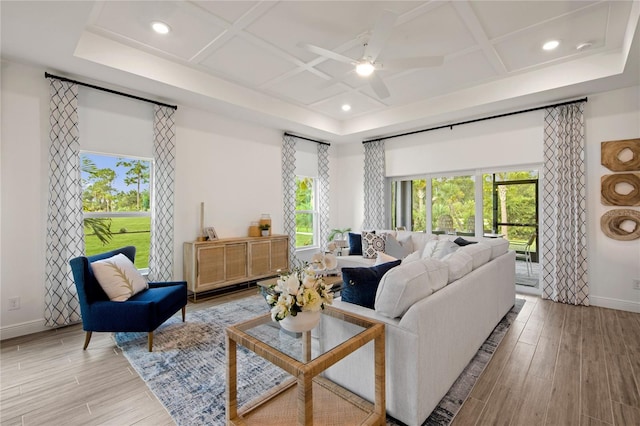 living room with coffered ceiling, ceiling fan, and light hardwood / wood-style floors