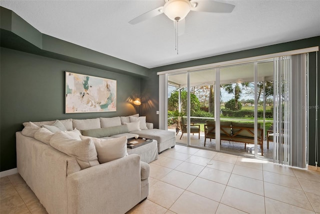 living room with ceiling fan, a textured ceiling, and light tile patterned floors