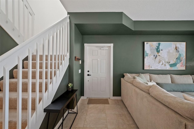 entryway with a textured ceiling and light tile patterned floors