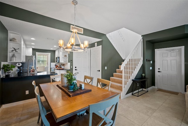 tiled dining area featuring an inviting chandelier