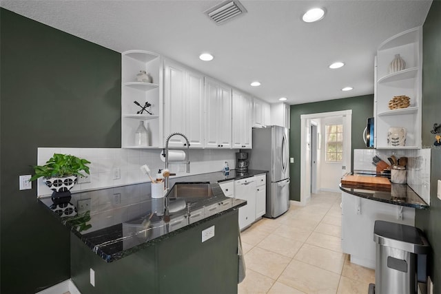 kitchen featuring tasteful backsplash, stainless steel appliances, light tile patterned floors, sink, and white cabinets