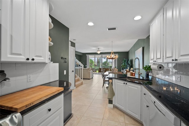 kitchen featuring tasteful backsplash, white cabinetry, light tile patterned floors, sink, and dishwasher