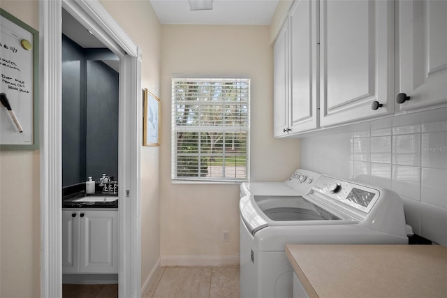 clothes washing area with cabinets, sink, independent washer and dryer, and light tile patterned floors