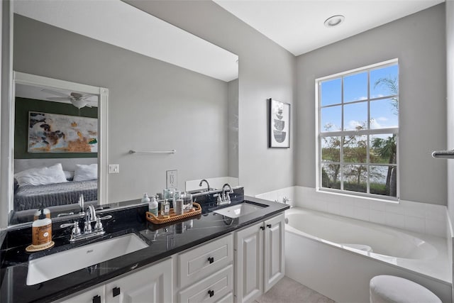 bathroom featuring vanity, a tub to relax in, and ceiling fan