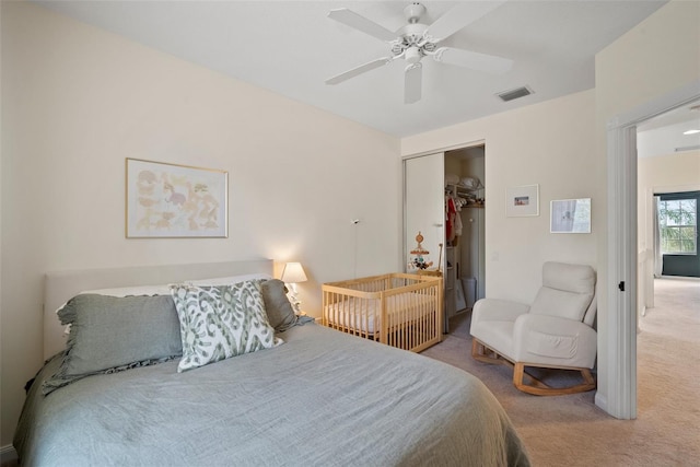 carpeted bedroom featuring ceiling fan and a closet